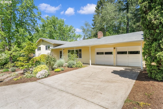 split level home featuring a garage, concrete driveway, and a chimney