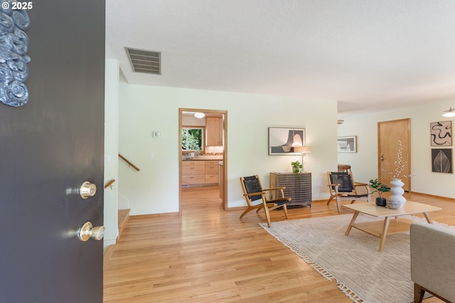 living room with light wood finished floors and stairway