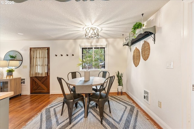 2906 SW Spring Garden St, Portland, OR 97219 - dining space featuring wood finished floors, a textured ceiling, and baseboards