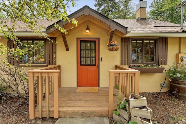 2906 SW Spring Garden St, Portland, OR 97219 - entrance to property with stucco siding, a chimney, and a shingled roof