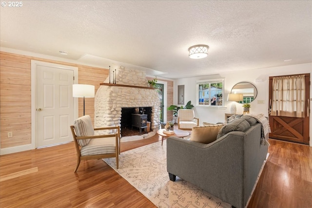 2906 SW Spring Garden St, Portland, OR 97219 - living area featuring a textured ceiling, wood finished floors, a wood stove, and baseboards
