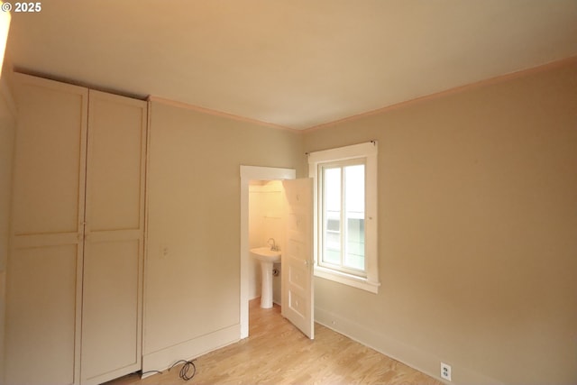 780 N 10th St, Coos Bay, OR 97420 - unfurnished bedroom featuring a sink, light wood finished floors, and baseboards