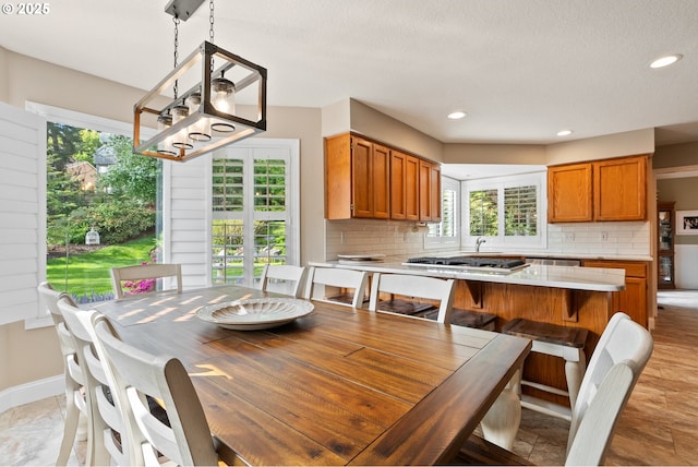 dining room featuring recessed lighting, baseboards, and a wealth of natural light
