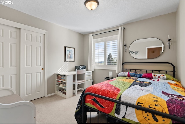 carpeted bedroom featuring a textured ceiling, baseboards, and a closet