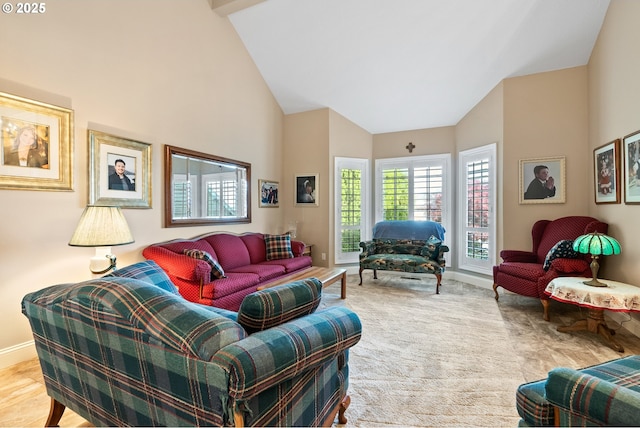 carpeted living area with high vaulted ceiling and baseboards