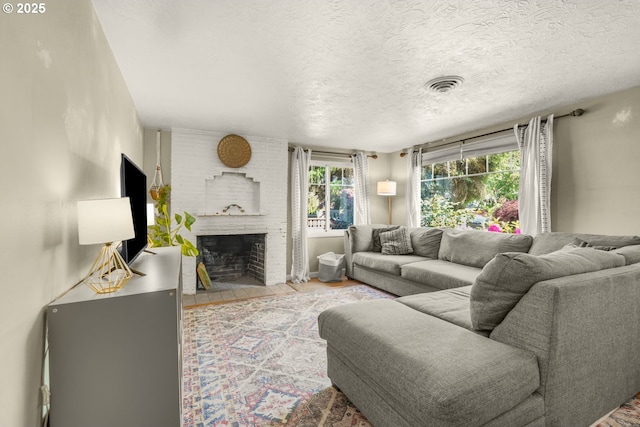 living room with a fireplace, a textured ceiling, and wood finished floors