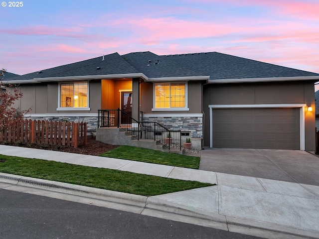 ranch-style house with roof with shingles, concrete driveway, an attached garage, fence, and stone siding