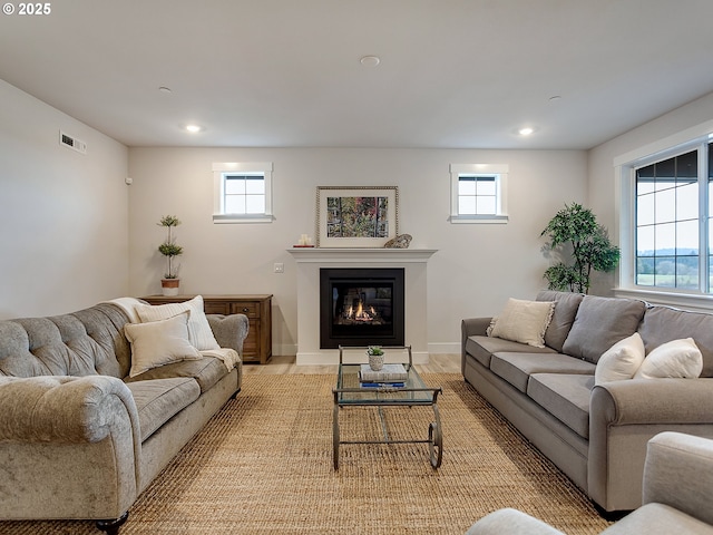 living area with plenty of natural light, a glass covered fireplace, and recessed lighting