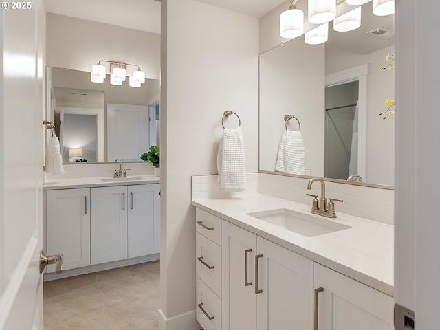 full bathroom featuring two vanities, a sink, and visible vents