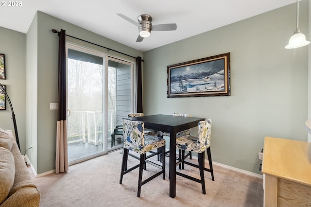 carpeted dining area with ceiling fan