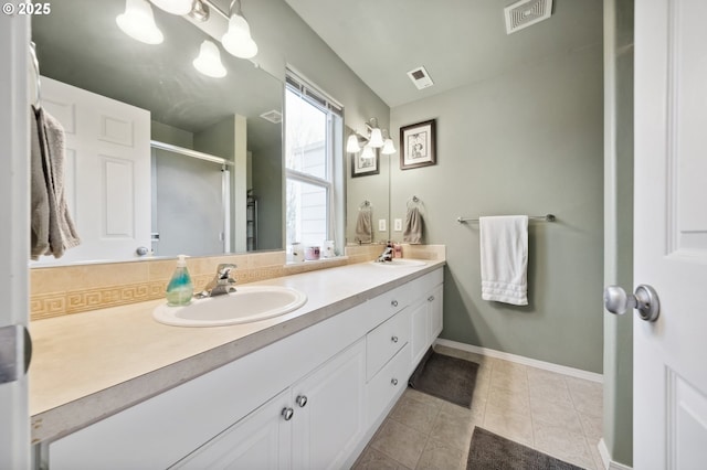 bathroom with tile patterned flooring, an enclosed shower, and vanity