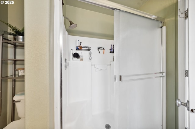 bathroom featuring toilet and an enclosed shower