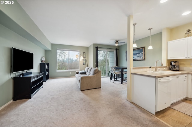 living room with sink, ceiling fan, and light colored carpet