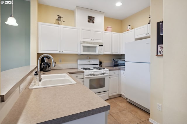 kitchen with white appliances, light tile patterned floors, pendant lighting, white cabinets, and sink