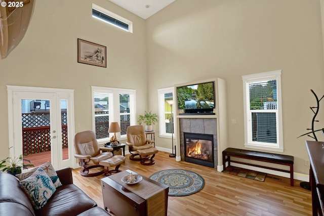 2146 NW Jetty Ave, Lincoln City, OR 97367 - living room with wood finished floors, a towering ceiling, a fireplace, and plenty of natural light