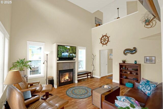 2146 NW Jetty Ave, Lincoln City, OR 97367 - living room featuring a high ceiling, wood finished floors, plenty of natural light, a tile fireplace, and baseboards