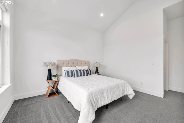 bedroom with dark carpet and lofted ceiling