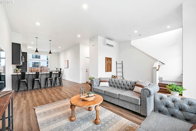 living room featuring light wood-type flooring and a wall unit AC