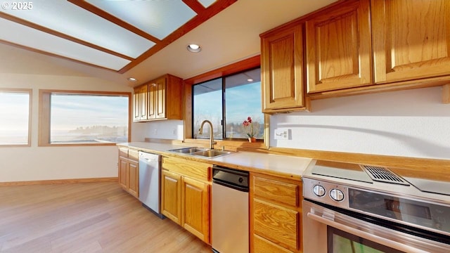 kitchen with light wood-type flooring, sink, vaulted ceiling, and appliances with stainless steel finishes