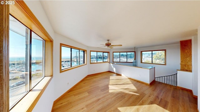 interior space with a water view and light hardwood / wood-style floors