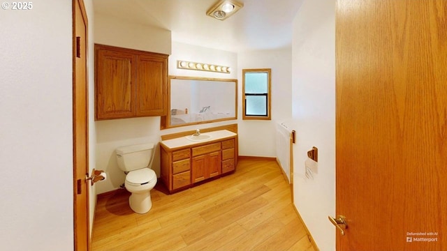 bathroom featuring vanity, hardwood / wood-style floors, and toilet