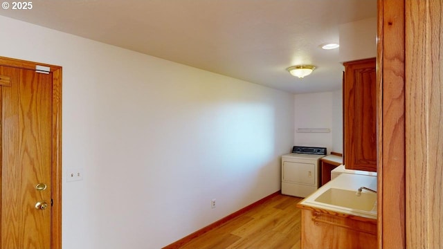 16151 Lower Harbor Rd, Brookings, OR 97415 - laundry room featuring a sink, light wood-style floors, baseboards, cabinet space, and washer / dryer