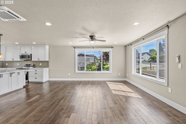 151 Alpha Dr, Longview, WA 98632 - unfurnished living room with dark wood-style flooring, baseboards, a ceiling fan, recessed lighting, and a textured ceiling