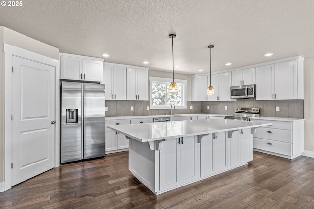 151 Alpha Dr, Longview, WA 98632 - kitchen featuring stainless steel appliances, dark wood-style floors, white cabinets, light countertops, and tasteful backsplash