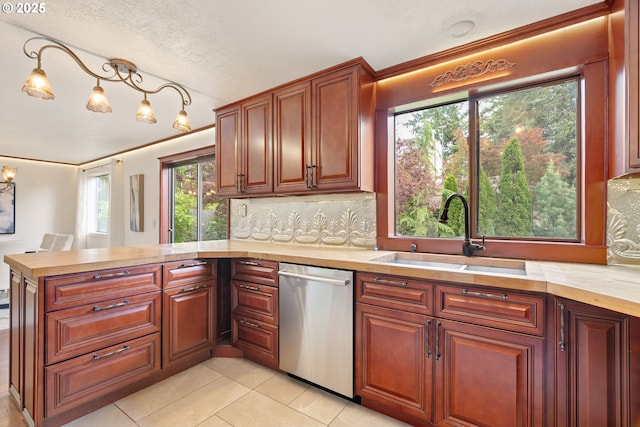 kitchen featuring stainless steel dishwasher, a sink, a peninsula, tasteful backsplash, and light tile patterned floors