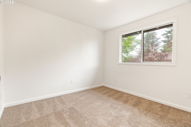 carpeted spare room featuring baseboards