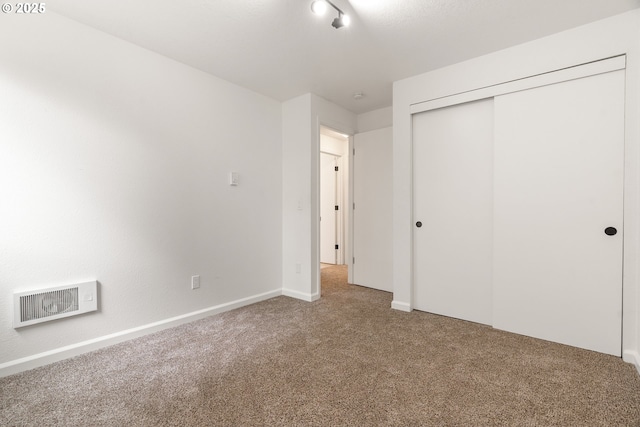 unfurnished bedroom featuring carpet, a closet, and baseboards