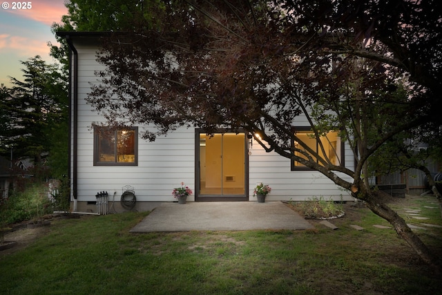 doorway to property featuring a patio and a yard