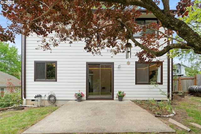 back of house featuring a patio, fence, heating fuel, and crawl space
