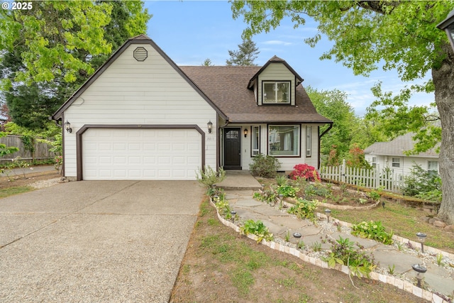 view of front of property with driveway, fence, a garage, and roof with shingles