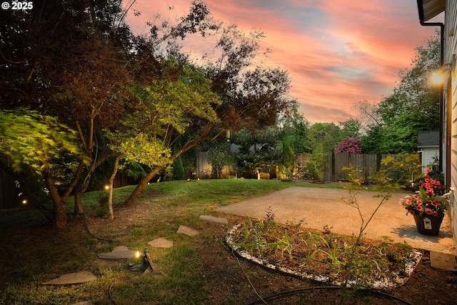 yard at dusk featuring a patio