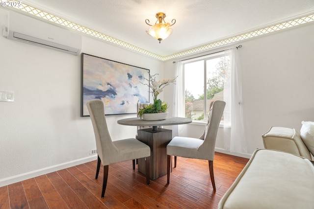 dining space with a wall mounted air conditioner, wood finished floors, and baseboards