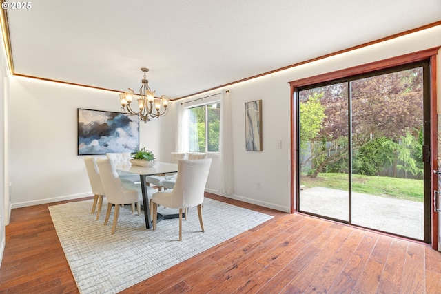 dining area with a chandelier, baseboards, and wood finished floors