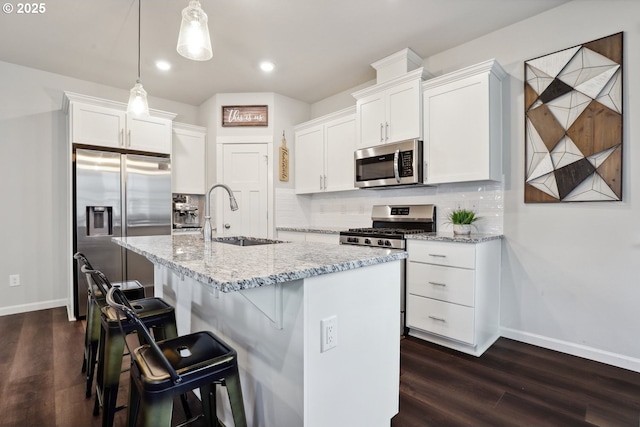 kitchen featuring white cabinetry, backsplash, appliances with stainless steel finishes, and a sink