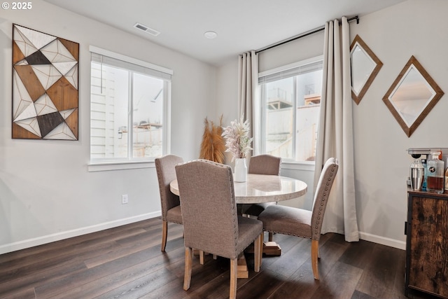 dining area with dark wood finished floors, baseboards, and visible vents