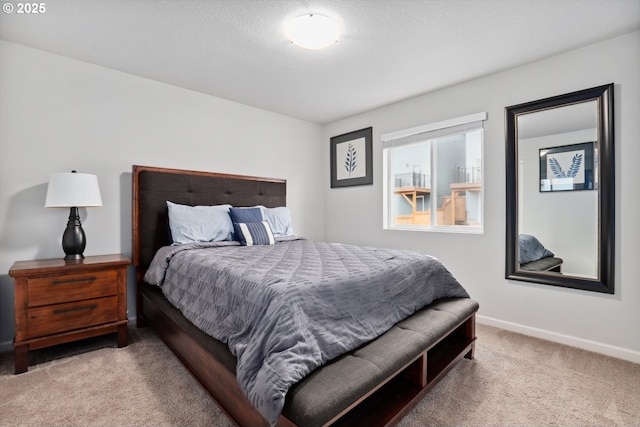 bedroom with carpet flooring, a textured ceiling, and baseboards