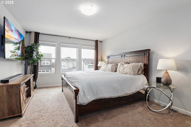 bedroom with light colored carpet and baseboards