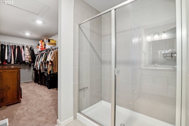 bathroom with a spacious closet, visible vents, and a stall shower