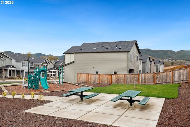 exterior space with a mountain view, fence, a residential view, and a lawn