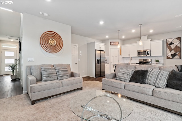 living room featuring recessed lighting, wood finished floors, and baseboards