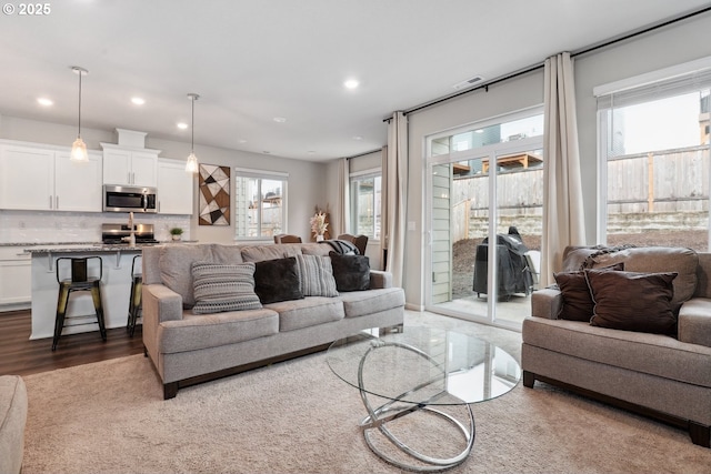 living area featuring recessed lighting, a healthy amount of sunlight, and wood finished floors