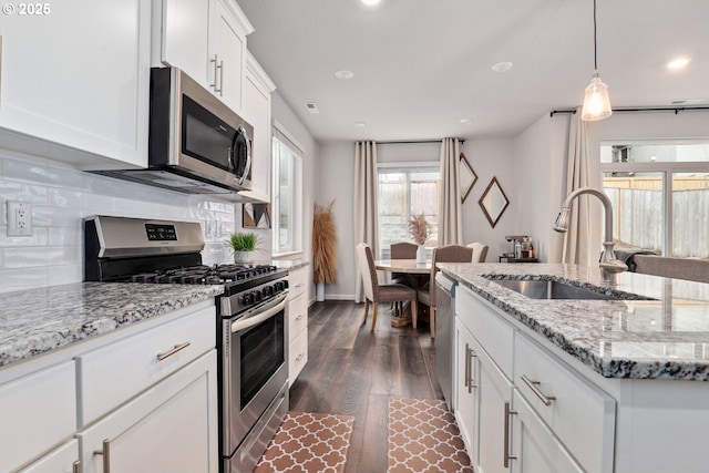 1327 19th Ave, Forest Grove, OR 97116 - kitchen with appliances with stainless steel finishes, dark wood-style flooring, tasteful backsplash, white cabinets, and light stone countertops