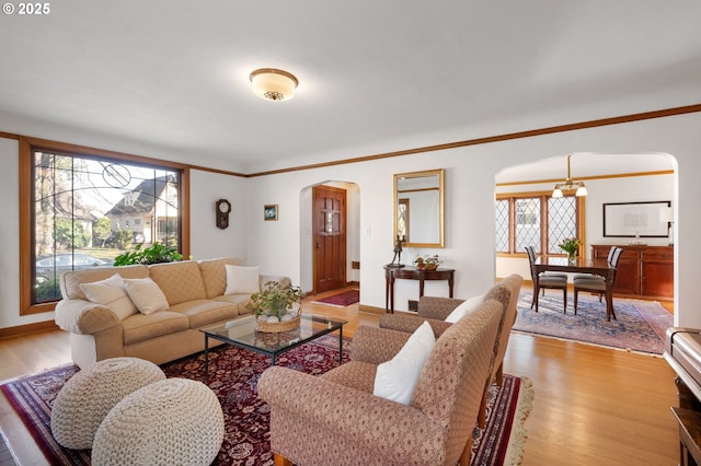 7115 N Chase Ave, Portland, OR 97217 - living room featuring arched walkways, plenty of natural light, light wood-style floors, and ornamental molding