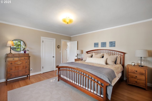 bedroom with ornamental molding, baseboards, and wood finished floors