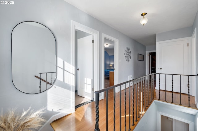 hallway featuring an upstairs landing and wood finished floors