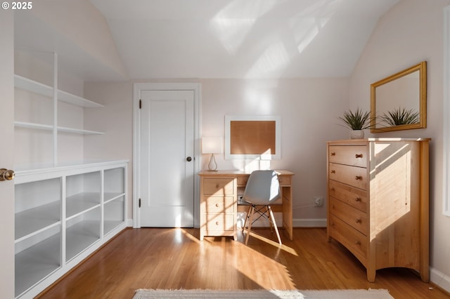 home office featuring baseboards, vaulted ceiling, and wood finished floors